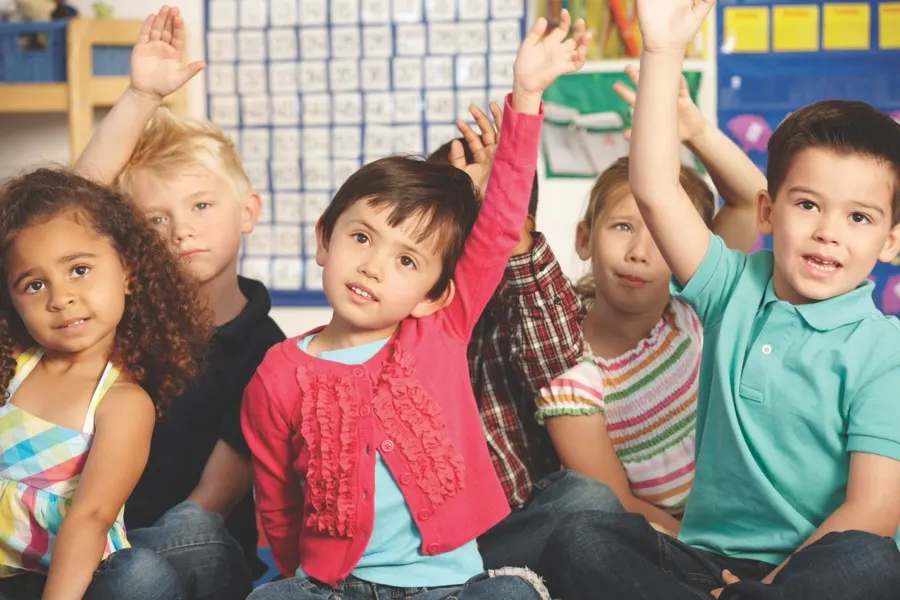 Students with hands raised during class