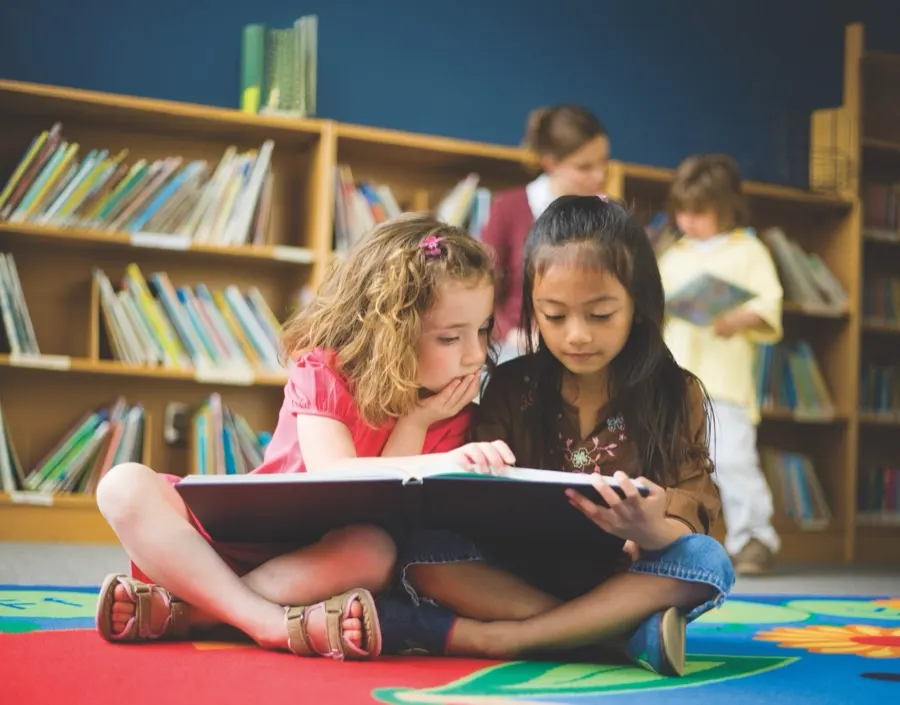 Two students reading together in the school library