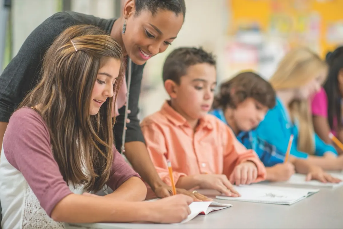 A teacher helping students with their classwork